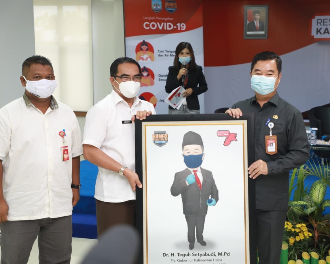 Pjs Gubernur Kaltara Teguh Setyabudi saat menerima karikatur dari Humas Kaltara