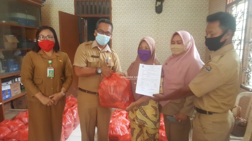 Kepala Dinsos Kaltara Heri Rudiono saat menyerahkan Bansos Sembako kepada salah satu warga terdampak Covid-19, Senin (26/10)