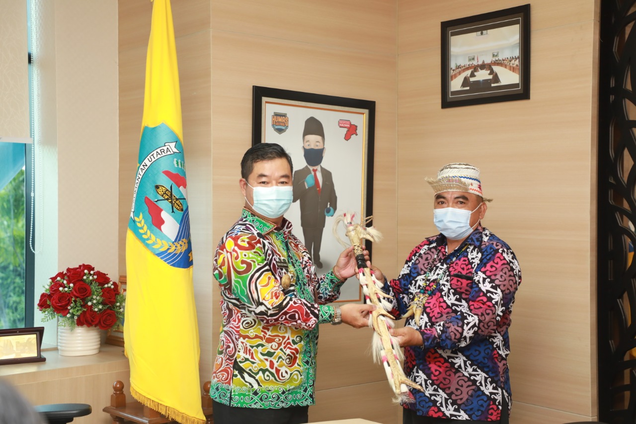 Pjs Gubernur Kaltara Teguh Setyabudi terima kenang-kenangan berupa Mandau dari Kepala Adat Besar Bahau Hulu, Baya Ajan setelah menyampaika aspirasi untuk pengembangan Lapter Long Alango, Malinau.
