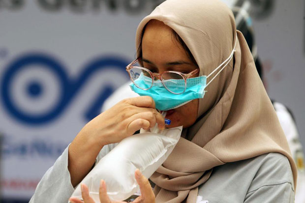Calon penumpang kereta menghembuskan napas ke dalam kantung GeNose C19. (Foto : Ist)